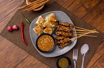 pork satay sate babi pork satay served with peanut sauce slices lontong ketupat rice cakes